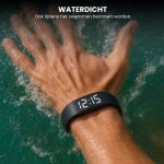 Hand met zwarte trilarmband met digitale tijd 12:15 onder water.