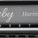 Zwarte Clerby mondharmonica met zilveren randen en de tekst "Clerby Harmonica" erop. Cijfers 1 t/m 10 zijn aangegeven.