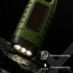 Groene, waterdichte zaklamp met 3 LED-lampen die schijnen op een steen.