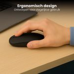 Hand bedient een ergonomische zwarte Clerby muis op een houten bureau.