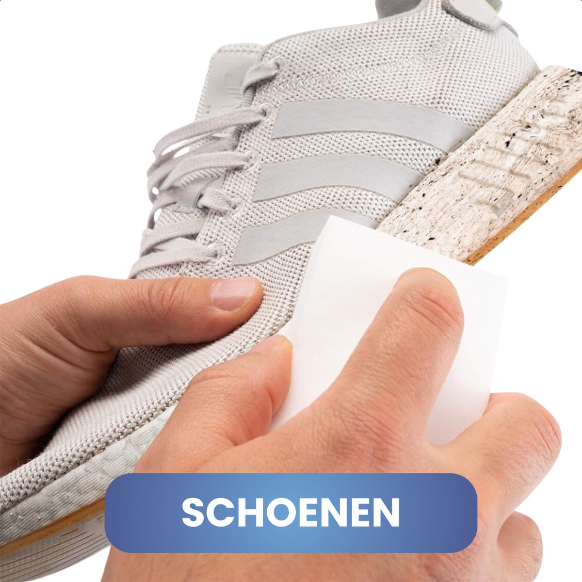 Handen maken een lichte stoffen sportschoen schoon met een witte wonderspons.