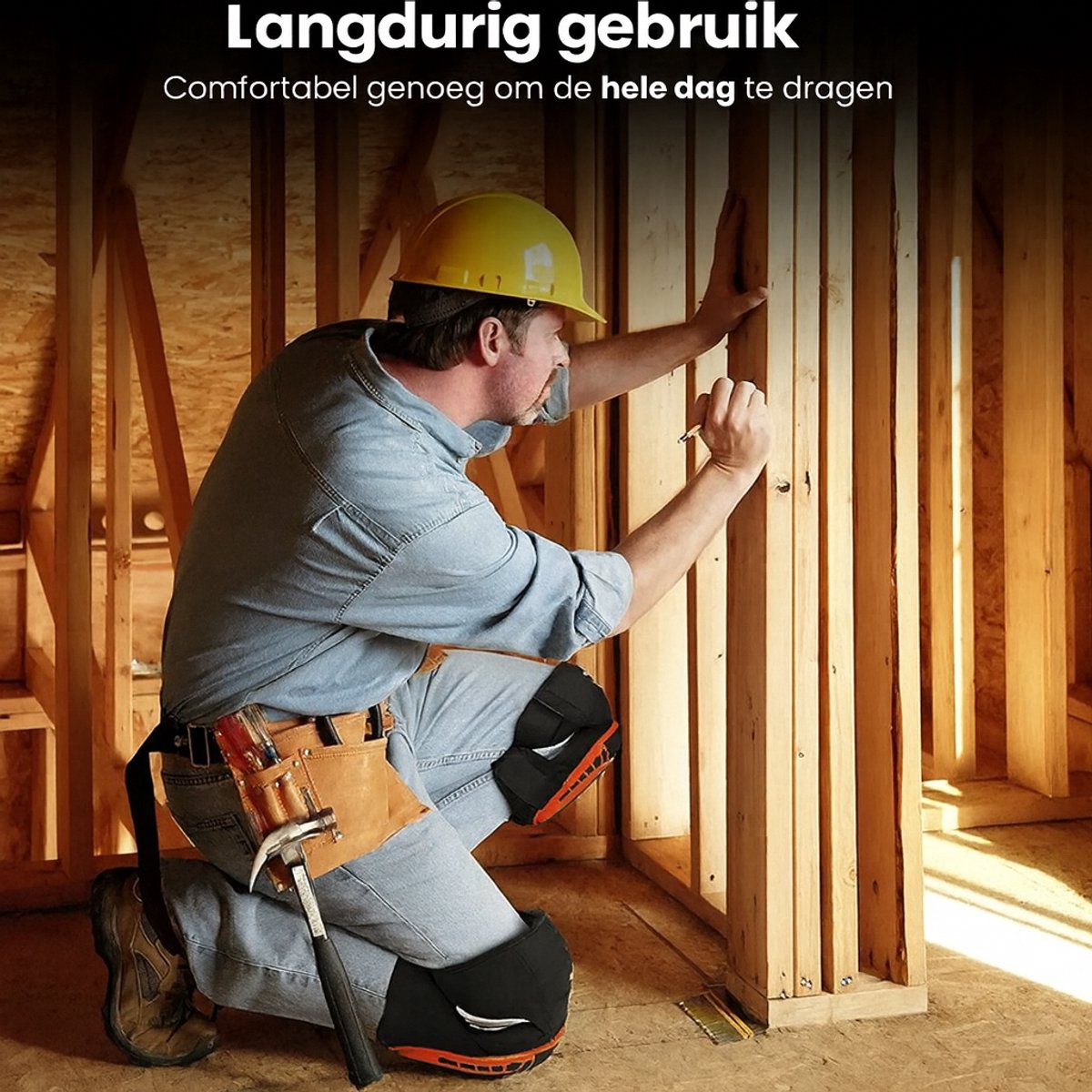 Bouwvakker met gele helm knielt en werkt aan een houten constructie, draagt zwarte kniebeschermers met oranje details.