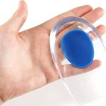 Een hand die een transparant gel-hielcupje met een blauw ovaal vasthoudt.